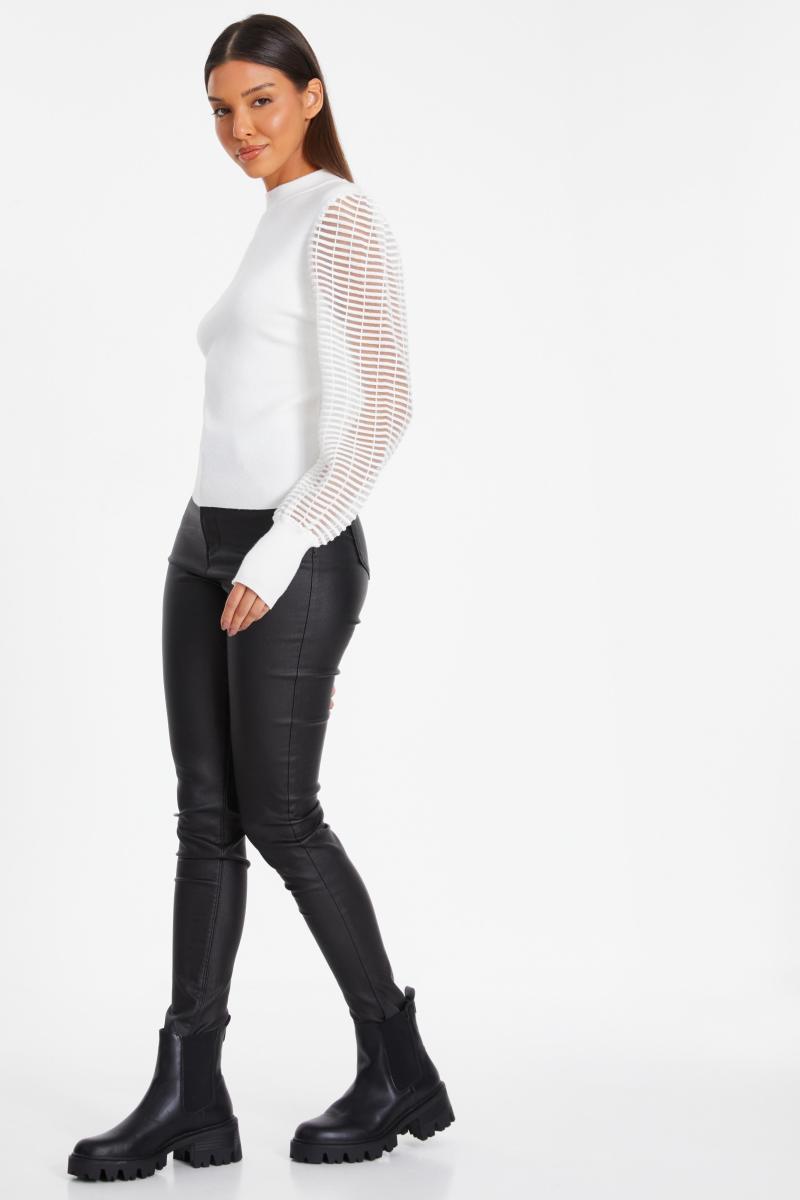 Біля білого джемпера з високою шиєю