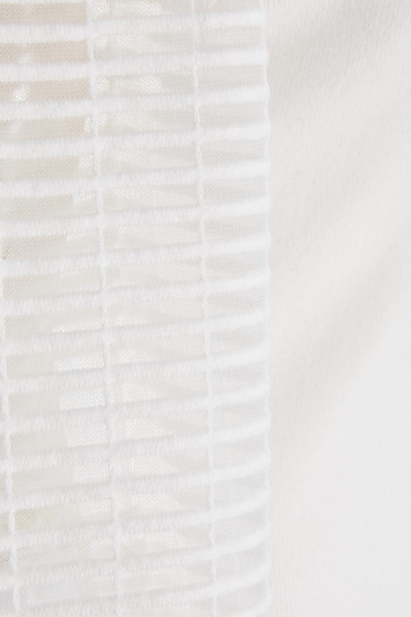 Біля білого джемпера з високою шиєю